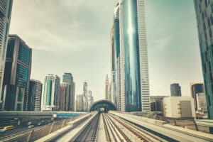 Retro toned photo of Dubai modern downtown seen from metro train, United Arab Emirates.