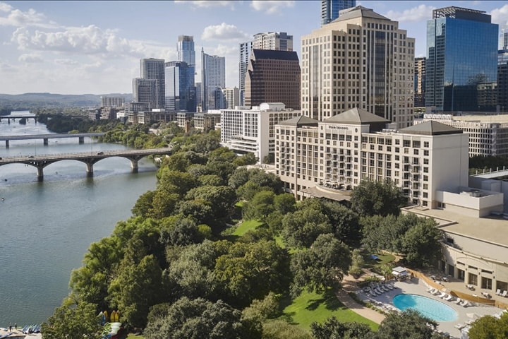 Four Seasons Hotel in the downtown Austin area surrounded by trees and other buildings