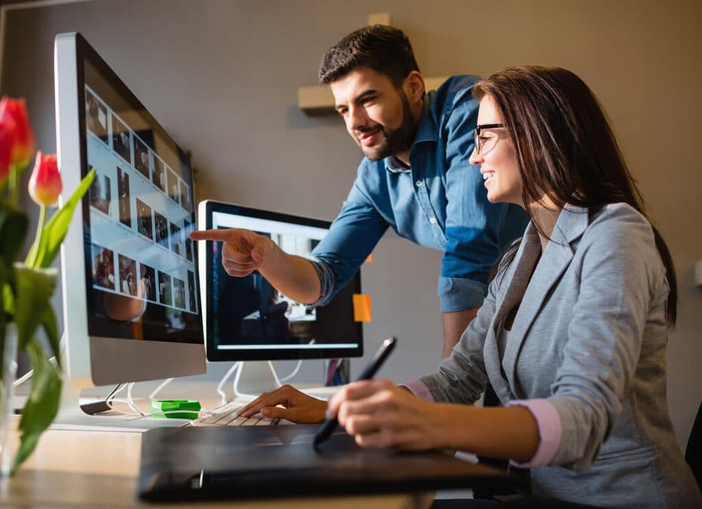 Man and woman working together on a web project at a desk