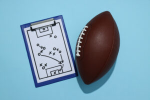 Football with Playbook next to it